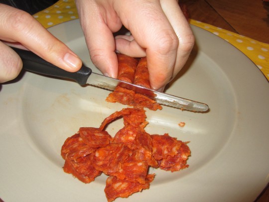 Die Chorizo in Scheiben schneiden - bei uns Männerarbeit, weil ER dabei schon probieren kann...