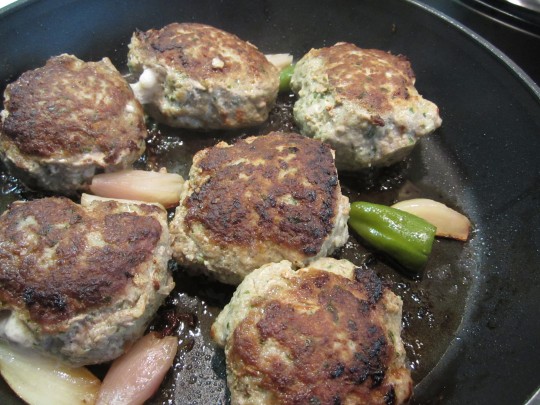 Da braten unsere Lamm-Pflanzerl, werfen Sie ein, zwei Pimentos und ein paar große Stücke Zwiebeln mit in die Pfanne.