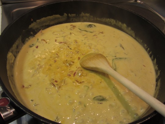 Kokosmilch und gelbe Curry-Paste mit der Zwiebel-Knoblauch-Chili-Mischung verrühren und köcheln lassen